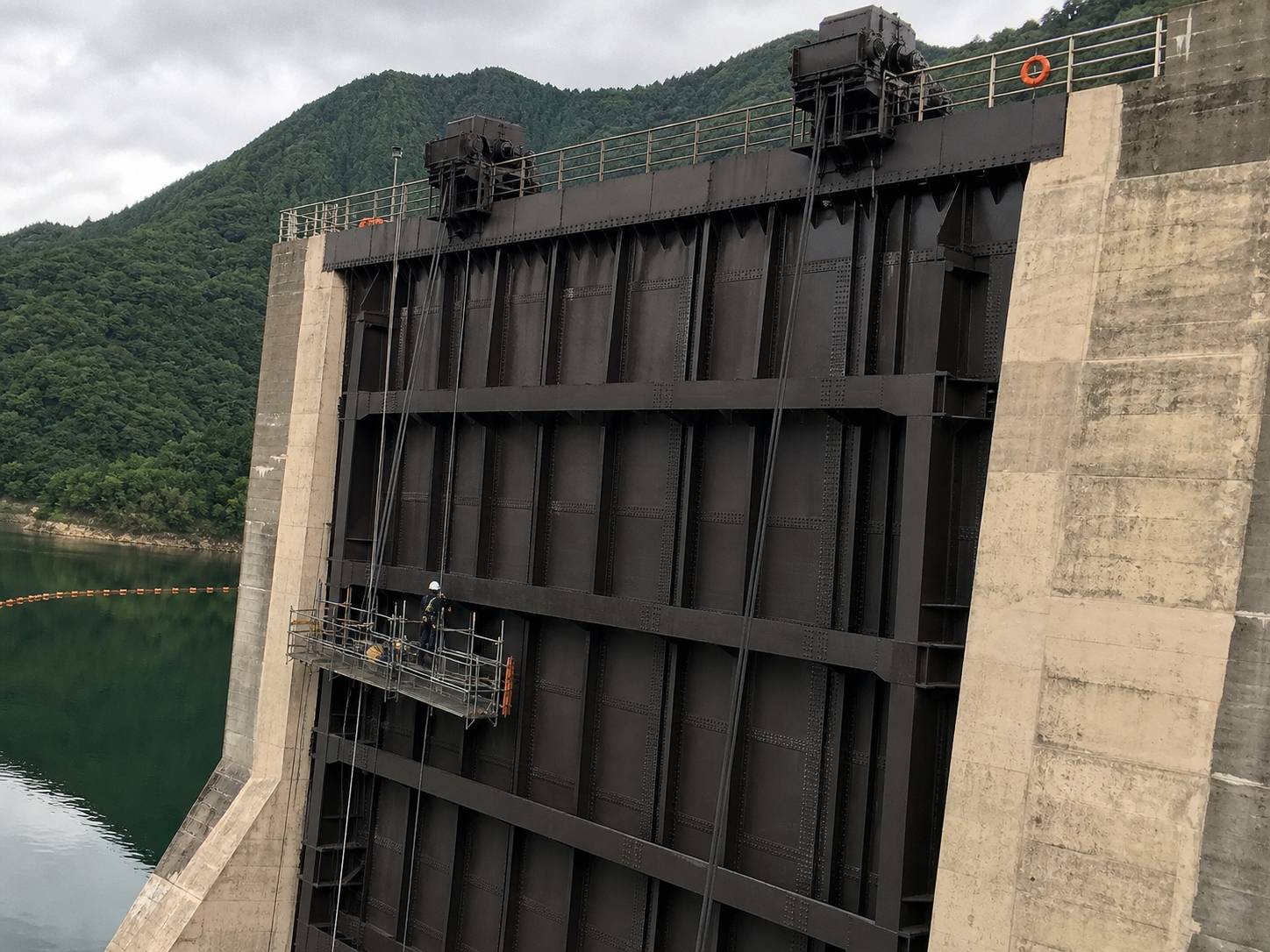 山あいのダムの鋼製ゲートと塗装用の足場